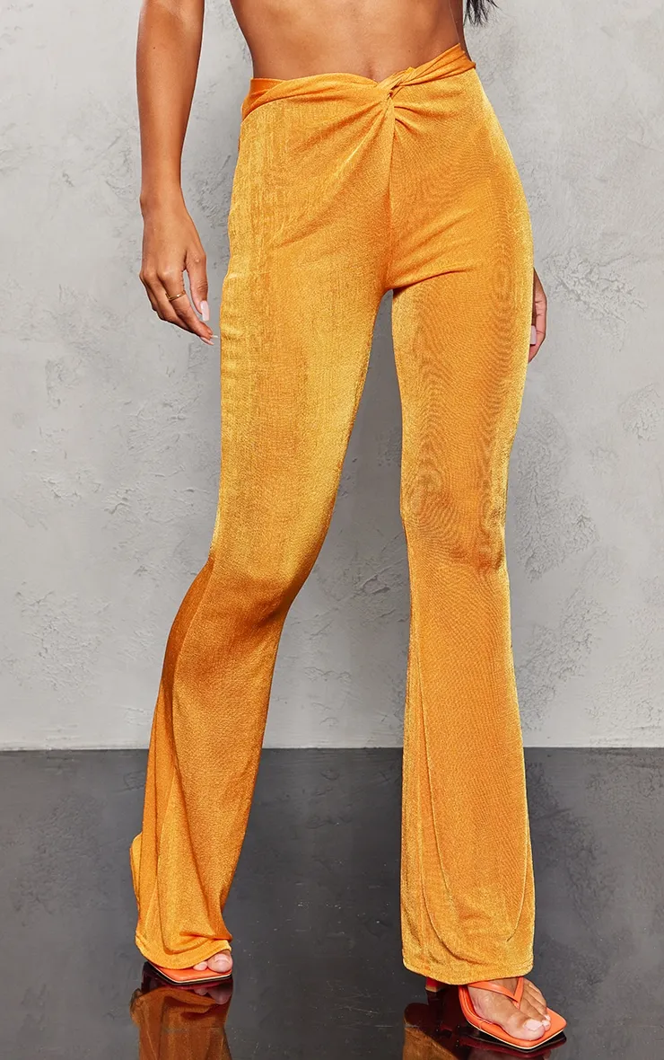 Pantalon flare moulant en acétate orange vif torsadé devant